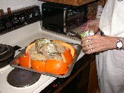 Pork roast with a headstart covered roasting now surrounded by pumpkin and covered with cabbage and sauerkraut